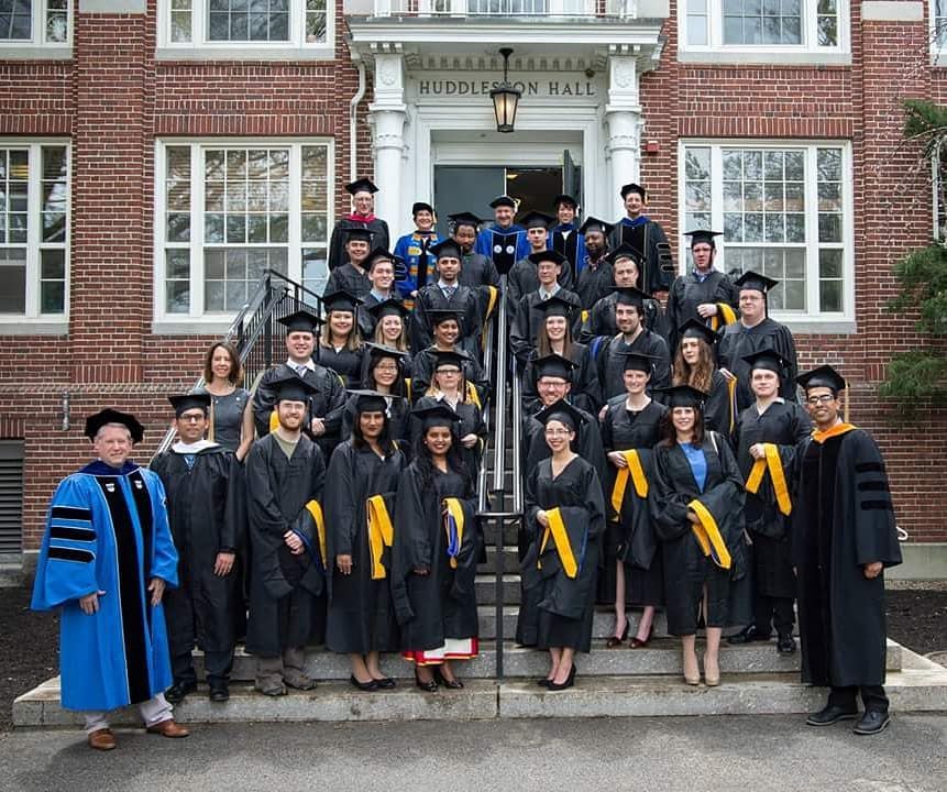 UNH’s 2018 graduate analytics and data science class in caps and gowns on the steps of Huddleston Hall